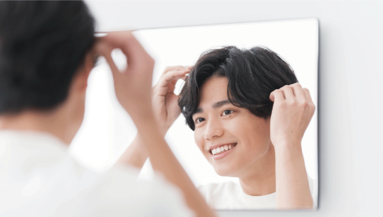 ヘアスタイリングをしながら笑顔の男性