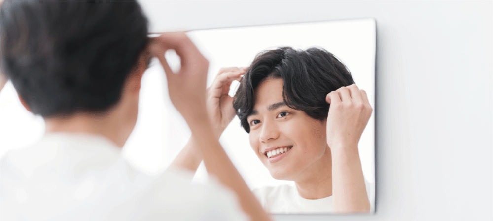 ヘアスタイリングをしながら笑顔の男性