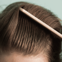 ヘアコームで髪を疏している男性