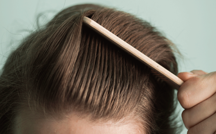 ヘアコームで髪を疏している男性