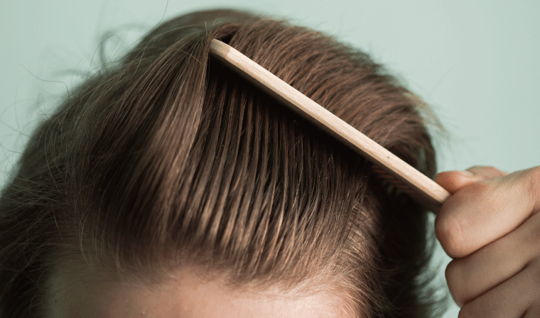 ヘアコームで髪を疏している男性