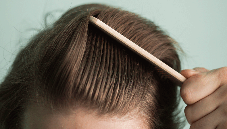 ヘアコームで髪を疏している男性