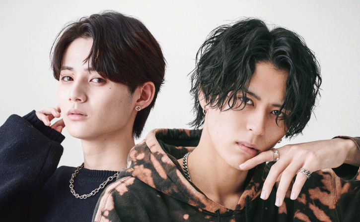 ニュアンスパーマとスパイラルパーマのセンターパートの男性2人が並んでいる