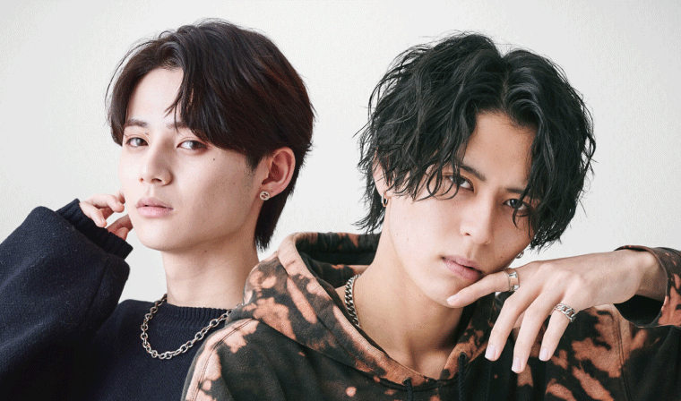 ニュアンスパーマとスパイラルパーマのセンターパートの男性2人が並んでいる
