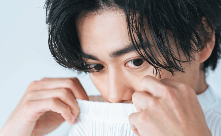 服の臭いを嗅いでいる男性