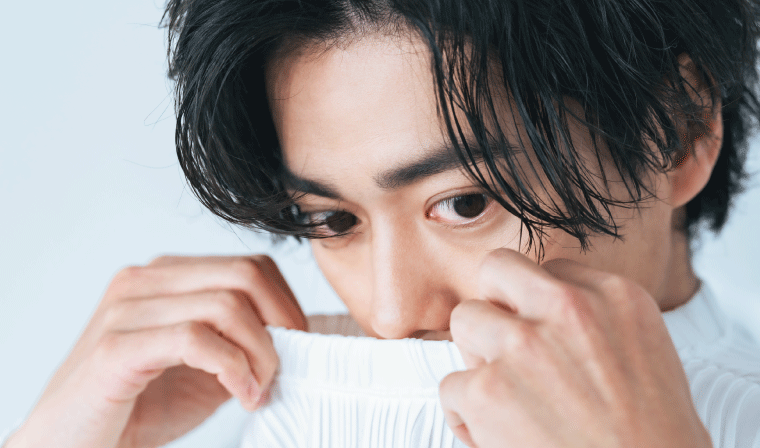 服の臭いを嗅いでいる男性